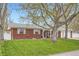 Beautiful brick home with a lush green lawn, mature trees, and inviting front porch at 9580 W 12Th Pl, Lakewood, CO 80215