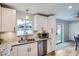 Modern kitchen with white cabinets, stainless steel appliances, granite countertops, and a tile backsplash at 9580 W 12Th Pl, Lakewood, CO 80215
