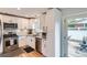 Modern kitchen featuring white cabinets, stainless steel appliances, granite countertops, and access to patio at 9580 W 12Th Pl, Lakewood, CO 80215