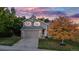 Two-story home with gray siding, a two-car garage, and a well-manicured lawn at 6512 S Taft Way, Littleton, CO 80127
