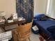 Cozy bedroom with wood desk and blue accents, featuring a large window at 1207 Joliet St, Aurora, CO 80010