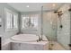 Bright bathroom featuring a soaking tub with marble surround and separate glass enclosed shower at 6526 N Windfield Ave, Parker, CO 80134