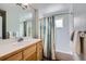 Well-lit bathroom with a single sink vanity and a shower tub combo featuring colorful curtain at 6526 N Windfield Ave, Parker, CO 80134