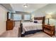 Cozy bedroom with a wooden bed, dresser, nightstand, and soft carpet, bathed in gentle light at 6526 N Windfield Ave, Parker, CO 80134