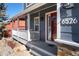 Inviting front porch with a red door, white railing, and a cozy seating area at 6526 N Windfield Ave, Parker, CO 80134