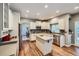 Bright kitchen features an island, stainless appliances, mosaic backsplash, and hardwood flooring at 6526 N Windfield Ave, Parker, CO 80134