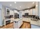Bright kitchen features white cabinets, an island, stainless appliances, and hardwood flooring at 6526 N Windfield Ave, Parker, CO 80134