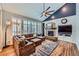 Living space with ceiling fan, fireplace, large windows, and hardwood floors at 6526 N Windfield Ave, Parker, CO 80134