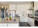 Charming kitchen with white cabinetry, a farmhouse sink, stainless steel appliances, and dark wood floors at 722 Hutchinson St, Louisville, CO 80027