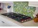 Modern kitchen stove top with colorful backsplash, electric cooktop, and stylish knife block at 722 Hutchinson St, Louisville, CO 80027