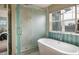 Spa-like main bathroom with a soaking tub, frameless shower, and mosaic tile accents at 722 Hutchinson St, Louisville, CO 80027