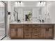 Luxurious bathroom featuring a double vanity with a light wood finish, quartz countertops, and sleek black fixtures at 9140 Moondance Dr, Littleton, CO 80125