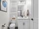 Bright, white bathroom with modern fixtures, including a vanity with storage and updated toilet at 9140 Moondance Sw Dr, Littleton, CO 80125