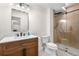 Bathroom features a wood vanity with quartz countertop and glass shower with wood look tile at 9140 Moondance Sw Dr, Littleton, CO 80125
