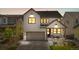 Charming two-story home with landscaped front yard, covered porch, and attached two car garage at dusk at 9140 Moondance Sw Dr, Littleton, CO 80125
