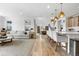 Bright open-concept living space with hardwood floors, modern furnishings, and abundant natural light at 9140 Moondance Sw Dr, Littleton, CO 80125