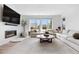 Bright living room featuring modern fireplace, large windows, and a plush sectional sofa at 9140 Moondance Sw Dr, Littleton, CO 80125