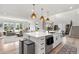 Spacious open-concept living area with kitchen island, stainless appliances, and staircase at 9140 Moondance Sw Dr, Littleton, CO 80125