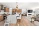 Open concept kitchen flows into living room with fireplace and contemporary furnishings under bright pendant lights at 9140 Moondance Sw Dr, Littleton, CO 80125