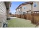Backyard featuring a patio, artificial grass, and a wooden fence at 2820 Macon Way, Denver, CO 80238