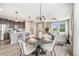 Open concept dining area with modern chandelier and furniture with a view into the living room at 2820 Macon Way, Denver, CO 80238