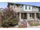 View of a charming home featuring a covered front porch, stylish exterior paint, and mature landscaping at 2820 Macon Way, Denver, CO 80238
