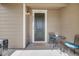 Home's front porch featuring a green front door and a quaint outdoor seating area at 2820 Macon Way, Denver, CO 80238