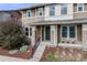 Two-story home featuring a covered front porch, stylish exterior paint, and pretty landscaping at 2820 Macon Way, Denver, CO 80238