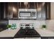 Close-up of kitchen features stainless steel Samsung appliances, white quartz countertops and honeycomb backsplash at 2820 Macon Way, Denver, CO 80238