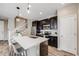 Charming kitchen features an island with stainless steel appliances, quartz countertop and dark wood cabinetry at 2820 Macon Way, Denver, CO 80238