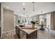 Open concept kitchen with stainless appliances and hardware, and a quartz countertop island overlooking the living spaces at 2820 Macon Way, Denver, CO 80238