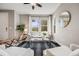 Bright living room features a ceiling fan, large windows, modern furniture, and a striped area rug at 2820 Macon Way, Denver, CO 80238