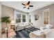 Bright living room features a ceiling fan, large windows, modern furniture, and a striped area rug at 2820 Macon Way, Denver, CO 80238
