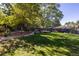 The landscaped backyard is adorned with trees, bushes, rocks and lush lawn at 6906 S Sycamore St, Littleton, CO 80120