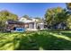 The backyard features a grassy lawn, a screened in porch, covered grill area, and a trampoline at 6906 S Sycamore St, Littleton, CO 80120