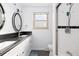 Bright bathroom features a dual sink vanity with dark countertop, subway tile shower, and modern fixtures at 6906 S Sycamore St, Littleton, CO 80120
