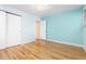 Empty bedroom with wood floors, light blue walls, and a closet at 6906 S Sycamore St, Littleton, CO 80120