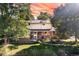 Attractive two-story brick home with a well-kept lawn and mature trees at 6906 S Sycamore St, Littleton, CO 80120