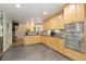Well-lit kitchen showcasing light wood cabinets, stainless steel appliances, and an open-concept design at 6906 S Sycamore St, Littleton, CO 80120