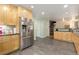 Modern kitchen with light wood cabinets, stainless steel refrigerator, and access to other rooms at 6906 S Sycamore St, Littleton, CO 80120