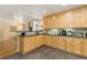 Open kitchen featuring light wood cabinets, bar seating, and an open layout to the adjoining living area at 6906 S Sycamore St, Littleton, CO 80120