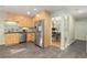 Bright kitchen features stainless steel appliances, light wood cabinets, and gray tile flooring at 6906 S Sycamore St, Littleton, CO 80120