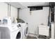 Bright laundry room with Samsung washer and dryer and utility sink is ready to tackle any mess at 6906 S Sycamore St, Littleton, CO 80120