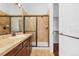 Bathroom featuring tile, a glass shower, dark vanity, and a walk-in closet at 7882 Vallagio Ln, Englewood, CO 80112