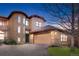 Beautiful two-story home featuring stone accents, a large garage, and a well-manicured lawn at 7882 Vallagio Ln, Englewood, CO 80112