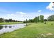 Scenic golf course view with a pond, lush green fairways, and mature trees under a bright blue sky at 7882 Vallagio Ln, Englewood, CO 80112