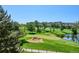 Expansive golf course view showcasing manicured greens, sand traps, a tranquil pond, and a clear blue sky at 7882 Vallagio Ln, Englewood, CO 80112