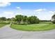 Manicured golf course view with a smooth concrete path, vibrant green grass, and distant building at 7882 Vallagio Ln, Englewood, CO 80112