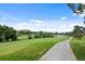 Picturesque golf course featuring a paved cart path winding through manicured greens and mature trees at 7882 Vallagio Ln, Englewood, CO 80112