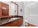 Cozy powder room with a dark vanity, mirror, and wood door at 7882 Vallagio Ln, Englewood, CO 80112